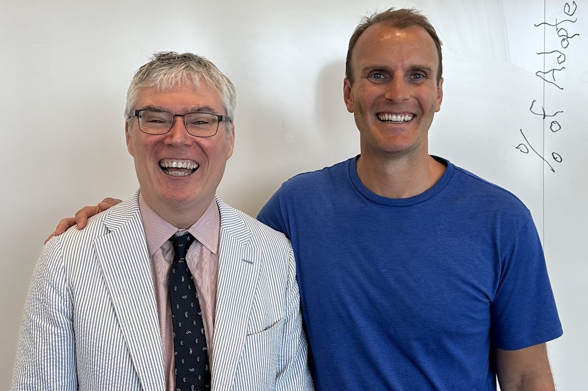 Jay laughing with Professor Paul Ingram in front of a whiteboard